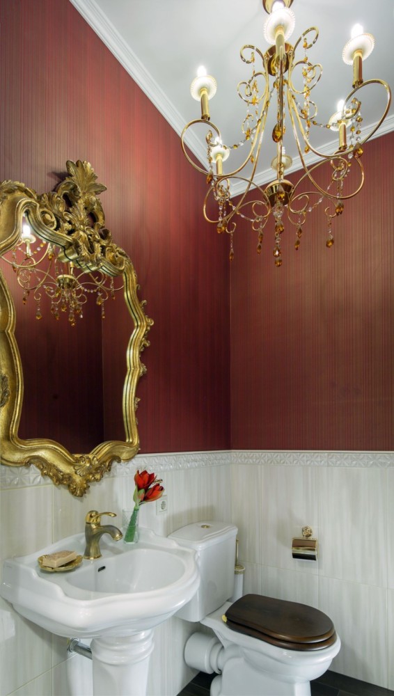 Гостевой санузел выполнен неординарно и ярко. Фоновая плитка подчёркивает необыкновенно сочные обои, золотое зеркало отражает прекрасную лёгкую золотую люстру. Есть ощущение парадности и гостеприимства.